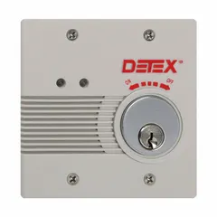 This standard door alarm features a mortise cylinder and produces a 100 dB horn sound when activated. The alarm body is gray plastic and is electrically corded. It is typically used to secure exit doors in commercial and industrial settings, alerting personnel when a door is opened.