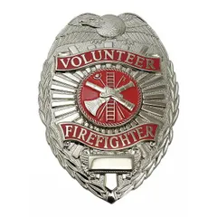 This oval metal badge measures 2 1/4 in x 3 1/8 in and features a silver finish. It is constructed of metal and includes a pin and safety catch for attachment. Typical use includes identification for uniformed personnel such as volunteer firefighters.