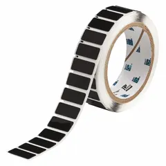 Polyester label roll with black gloss finish, precut to 31/64 x 1 19/32 inches, 250 labels per roll. Compatible with THT printer series. Used for industrial identification, such as labeling raised panel components in electrical cabinets and control panels.