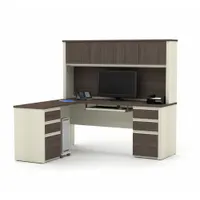 L-shaped desk constructed from laminate particle board with an Antigua finish desktop. Overall dimensions: 71 1/8 inches wide by 62 3/4 inches deep. Suitable for corner placement in professional office environments to support general desk work