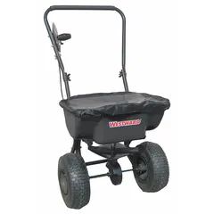 This manual walk-behind spreader is constructed with a steel frame and has a 30 lb capacity. It distributes seed, fertilizer, and other granular materials with a maximum spread width of 12 ft, suitable for lawn and agricultural applications.