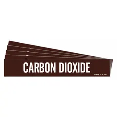 Brown adhesive pipe marker with white legend reading 'Carbon Dioxide'. Fits pipe outer diameters from 2-1/2 to 7-7/8 inches. Sold in a 5-pack with one marker per pack. No directional arrows. Used to label piping systems carrying carbon dioxide for clear identification.