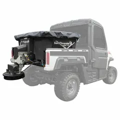 This broadcast spreader mounts in the bed of a truck or UTV and is powered by the vehicle battery. It features a stainless steel frame and a poly hopper, with a horizontal auger drive mechanism for distributing seed, fertilizer, or salt.