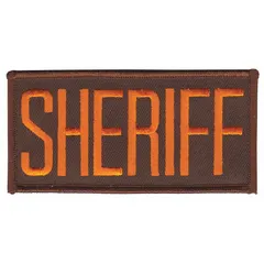 This embroidered insignia measures 4 inches by 2 inches and features a brown and gold color scheme. It is made of plastic and attaches via sewing onto chest areas of uniforms. Commonly used to denote sheriff designation on law enforcement or security attire.