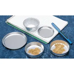 Round aluminum weighing boat with 60 mL capacity and 4 3/4 in overall width. Gray color, no finger tab. Used for weighing solid samples in laboratory settings.