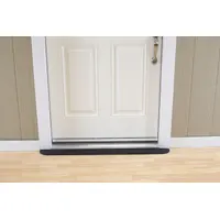 This black rubber ramp provides a smooth transition over door thresholds for wheelchairs, carts, and walkers. It is ADA compliant and commonly used in commercial facilities, warehouses, and industrial settings to improve accessibility and reduce trip hazards