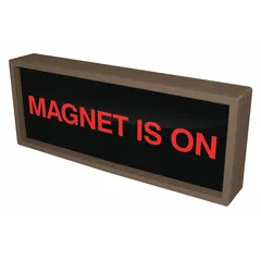 This backlit safety sign displays the message 'Magnet Is On' to warn personnel of active magnetic fields. It is used in industrial settings near magnetic separators, cranes, or material handling equipment to prevent accidents. The backlit design ensures legibility in low-light conditions.