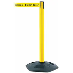 This retractable belt post barrier features a yellow plastic post with a black rubber base and a yellow belt printed with 'Caution Do Not Enter'. The belt extends up to 13 ft. Used to cordon off restricted areas and manage pedestrian traffic in warehouses, factories, and public spaces.
