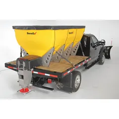 This SNOWEX tailgate spreader mounts in a truck bed and is powered by the vehicle battery. It features a stainless steel frame and a poly hopper, with a ground-driven broadcast mechanism for distributing salt, sand, or ice melt. Compatible with trucks.