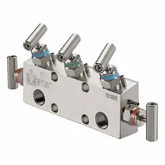 Stainless steel 5-valve manifold with 1/2" FNPT inlet and outlet connections, 1/4" FNPT drain, and 6000 psi pressure rating. PTFE sealing components. Used in industrial instrumentation systems for isolating, calibrating, and venting pressure instruments.