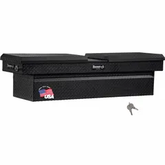 This crossover box features a gull wing lid design for easy access to stored items. Constructed of aluminum with a matte black finish, it measures 71 inches in overall width. Suitable for mounting atop pickup truck bed rails to provide organized storage for tools and equipment.