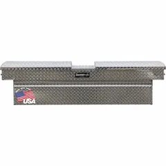 This crossover box features a gull wing lid and is constructed from aluminum with a silver finish. With an overall width of 71 inches, it is designed for mounting across a pickup truck bed to provide accessible storage for tools and equipment.