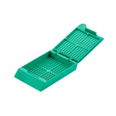 Embedding cassette made of polyoxymethylene in turquoise color. Overall length 1.65 inches, overall width 1.12 inches. Used in histology and pathology laboratories for embedding tissue samples in paraffin wax, holding specimens during processing, sectioning, and storage.