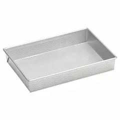 This straight side cake pan is constructed from aluminized steel with a glazed silver coating for even heat distribution. It features a closed bead closure and solid perforation, suitable for baking cakes, brownies, and sheet cakes in commercial foodservice environments.