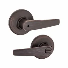 This KWIKSET privacy lever lockset is designed for interior doors requiring locking privacy, such as bathrooms or bedrooms. It features a satin bronze-plated, blackened, satin relieved, clear coated finish on zinc, with a rose-style trim. The lockset is ADA compliant and has an ANSI F76 function code. It is not ligature-resistant and has no visual indicator message.