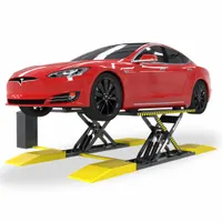 Hydraulic scissor lift with steel frame and two runways, rated for 6,000 lb. Operated via control box for lifting actuation. Used in automotive service centers for under-vehicle access during wheel alignment, brake, and suspension work on cars and light trucks