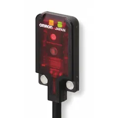 Rectangular photoelectric sensor from the OMRON E3T series with a PBT body and prewired cable terminated with bare wires. Operates on 12-24V DC supply with PNP output. Suitable for object detection in industrial automation, packaging, and material handling applications.