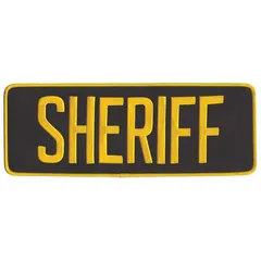 Embroidered patch featuring a sheriff design. Measures 11 inches by 4 inches with a black background and gold embroidery. Constructed from polyester and rayon with a backing for attachment. Suitable for uniform identification, ceremonial display, or collector insignia.