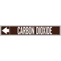Brown adhesive pipe markers with white legend reading 'Carbon Dioxide' and directional arrows. Each roll contains 25 markers fitting pipe outer diameters from 2-1/2 to 6 inches. Used to identify pipes carrying carbon dioxide in industrial piping systems