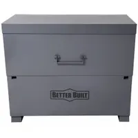 This piano-style jobsite box provides 47.8 cu ft of storage capacity with dimensions of 60 in width, 30 in depth, and 49 in height. It features a gray finish and a recessed padlock hasp for securing contents (lock not included). The full-width piano hinge allows easy access to stored tools, equipment, and materials on construction sites, in industrial facilities, or workshops