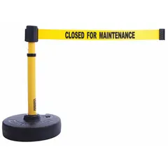 This retractable belt post barrier features a yellow post and base with a black belt displaying a 'Closed for Maintenance' message. The belt extends to 15 ft, making it suitable for cordoning off areas in industrial facilities, warehouses, and construction sites to manage pedestrian traffic and restrict access to hazardous or out-of-service zones.