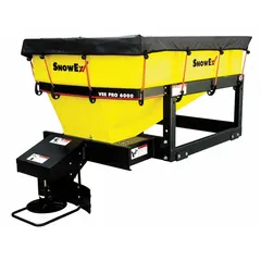 This broadcast spreader mounts in a truck bed and is powered by the vehicle's battery. It features a poly hopper and steel frame, designed for use with calcium flakes. Typical applications include spreading de-icing materials on roadways and parking lots.