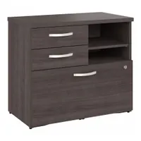 This desk-height storage cabinet is constructed of wood with a dark gray laminate finish. It features two shelves and a locking mechanism for securing contents. With an overall height of 26 inches, it is suited for organizing office supplies and documents in professional environments